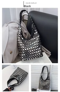 Détail du sac hobo noir en forme de lune avec des rivets métalliques ronds argentés