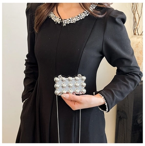 Detailed view of mini silver metallic evening bag with spherical rivets and chain strap