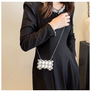 Detail of silver mini party bag featuring polished metallic spheres and slim chain strap