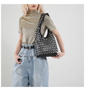 Detailaufnahme der schwarzen Ledertasche mit silbernen Nieten im Punk-Stil-Design