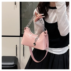 Detail of pink oil wax leather underarm bag with silver chain strap and metal pendant