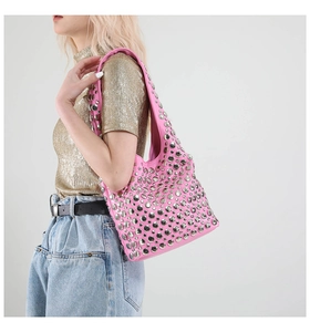 Seitenansicht einer rosa Hobo-Tasche aus Leder mit Nieten getragen von einem Model