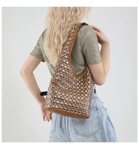 Braune Leder-Schultertasche mit silbernen Nieten präsentiert an einem weiblichen Model