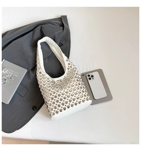 Detail der weißen Hobo-Tasche aus Leder mit silbernen Metallnieten und Punk-Elementen