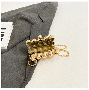 Detailed interior view of a golden bubble-textured mini evening bag with beaded chain strap