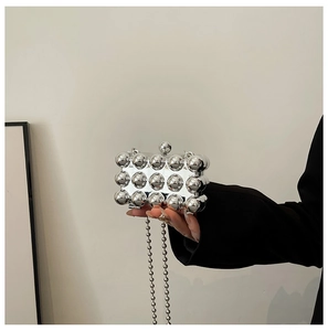 Detail of silver evening clutch bag with metallic spheres and round bead chain