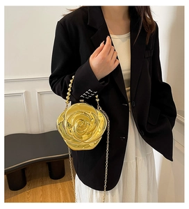 Detailed view of a golden rose-shaped evening clutch bag with 3D carved metallic petals