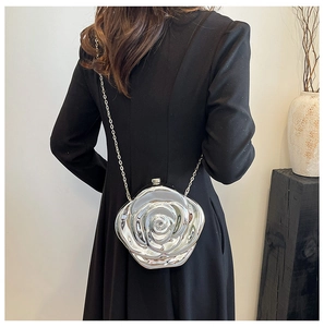Detailed view of silver rose shaped acrylic evening clutch with metal chain strap on model