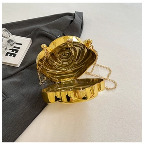 Close-up of golden rose-shaped metal clutch with intricate petal textures and chain