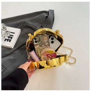 Interior view of heart-shaped gold clutch showing space for phones and lipstick