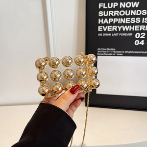 Mini transparent party clutch with gold studs and a sleek metal chain strap