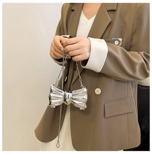 Mini silver bow-shaped metal chain bag with mirror finish and elegant pleated texture