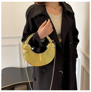 Detailansicht der goldenen sichelförmigen Abendtasche mit Rillenstruktur und Schulterkette