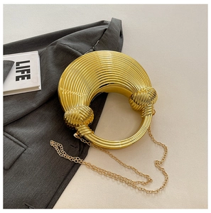 Detailansicht der runden goldenen Abendtasche mit strukturierten konzentrischen Kreisen