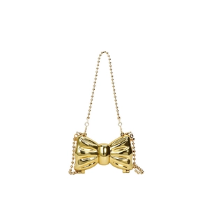 Detail of a mini gold bow-shaped metallic party bag with a beaded chain strap
