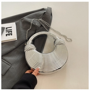 Nahaufnahme der silbernen Abendtasche mit Knotengriff und gerippter Oberflächenstruktur