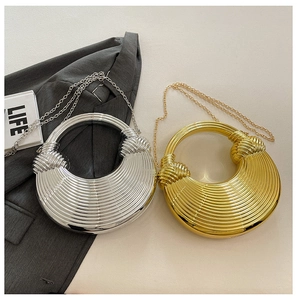 Details von metallischen halbkreisförmigen Abendtaschen in Gold und Silber mit Rippstruktur