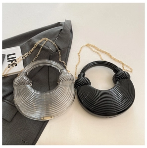 Detailaufnahme der Acryl-Handtasche mit kreisförmiger Textur und Goldkette