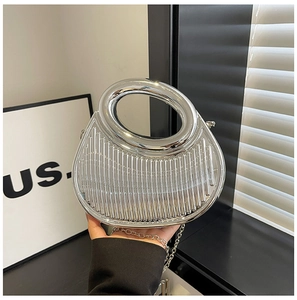 Close-up of silver semi-circular evening bag with vertical stripes and ring handle