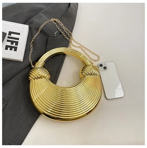 Detailansicht der goldenen Halbmond-Clutch mit gestreifter Metallstruktur und Kette