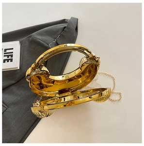 Detailansicht der goldenen Abendtasche mit glatter Beschichtung und abnehmbarer Kette