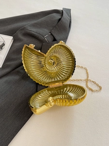 Detailed view of golden shell evening bag with metallic ribs and gold chain strap