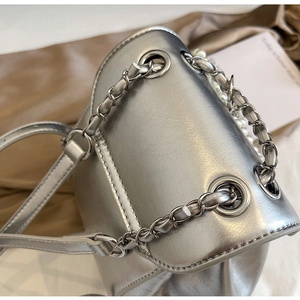 Detail of silver metallic leather texture and chain strap with elegant pearl accents