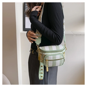Detailed close-up of mint green geometric saddle bag with striped wide strap and gold hardware