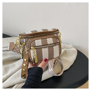 Close-up of canvas saddle bag with geometric patterns, double zippers, and wide strap