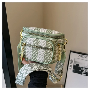 Detail of green diamond pattern woven crossbody bag with geometric embroidery wide strap