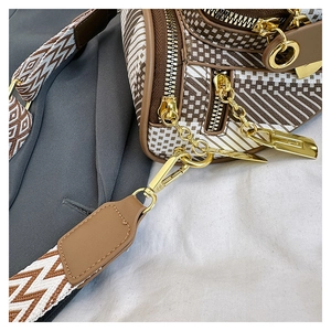 Detail of geometric pattern chest bag with woven strap and gold-tone hardware