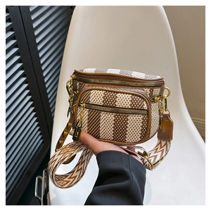 Close-up of geometric pattern saddle bag with wide shoulder strap and gold zippers