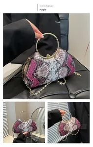 Detail of purple snakeskin evening bag featuring a gold ring handle and metal chain strap