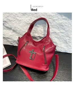 Detailed shot of burgundy crossbody bag with cross pendant and metal chain decoration