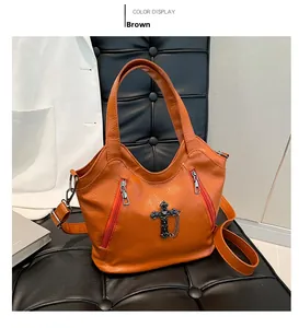 Retro brown faux leather tote bag detail with cross pendant and orange zip accents