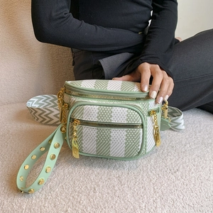 Green gingham crossbody saddle bag with gold zippers and wide wave pattern strap