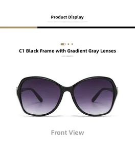 Detail of oversized black frame sunglasses with gradient grey lenses and gold metal hinges