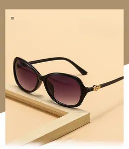 Detail of elegant black oversized sunglasses with purple gradient lenses and gold hinge
