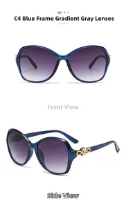 Detail of oversized blue sunglasses with gradient grey lenses and golden metal accents