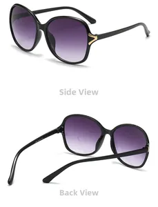 Macro view of oversized black sunglasses with gradient lenses and gold V-shaped metal trim