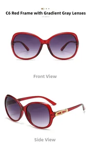 Detail view of red oversized sunglasses with golden metal hinges and gradient lenses