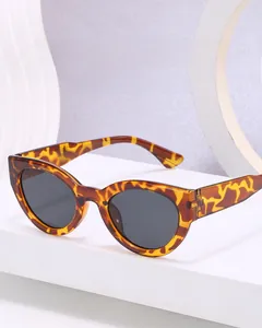 Détail macro de lunettes de soleil œil-de-chat écaille de tortue sur socle blanc