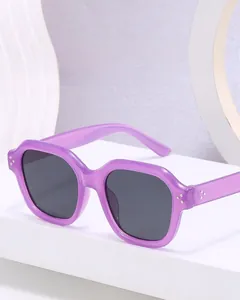 Close-up of stylish purple polygon sunglasses with silver rivets and grey lenses