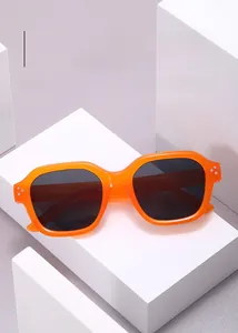 Detailed view of translucent orange square sunglasses with silver rivet accents