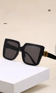 Detail von quadratischer übergroßer Sonnenbrille mit gelbem Doppelring-Logo am Bügel