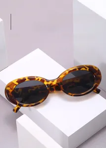 Detail of vintage leopard print oval sunglasses on white geometric display stand