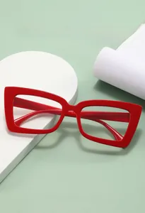 Nahaufnahme der hellroten Cat-Eye-Brille BJ5 mit dickem Rahmen auf Requisiten