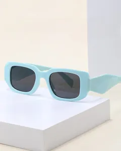 Close-up of mint green rectangular sunglasses with thick frames and geometric temples