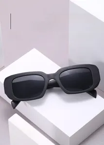 Detail of rectangular wide-frame sunglasses on geometric stand for fashion street style