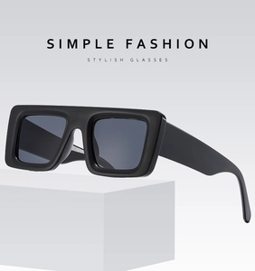 Detail of oversized black rectangular sunglasses with thick frames and dark grey lenses